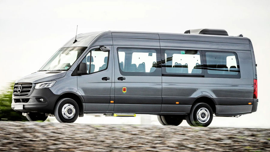 Van Mercedes Sprinter cinza em movimento, modelo espaçoso e confortável para transporte de grupos em viagens, usada como imagem ilustrativa do artigo
