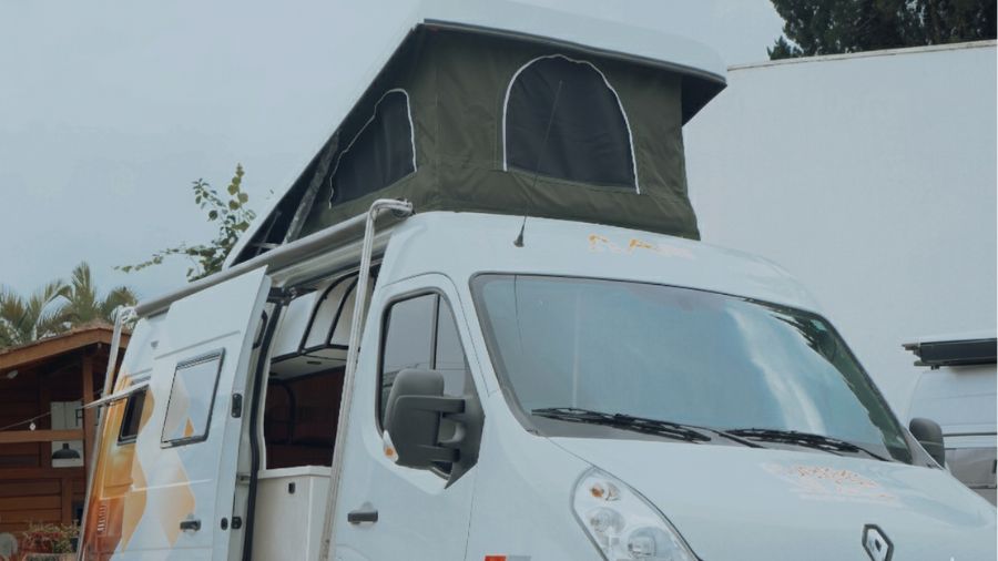 Escada de madeira e frigobar embutido no interior de um motorhome compacto